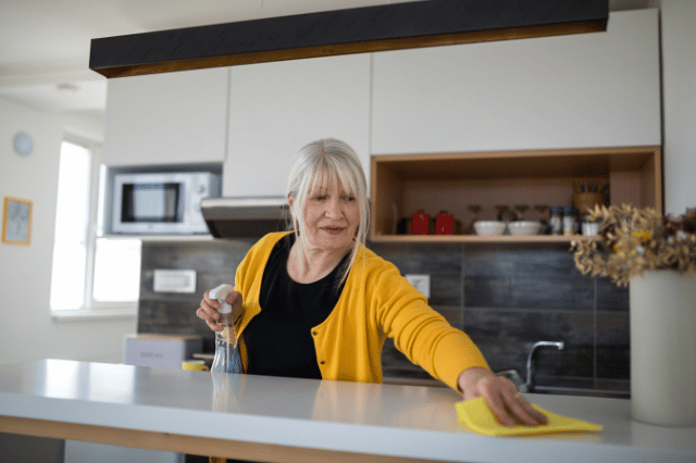 Cleanliness is Next to Creativity Middle Aged Woman Wipes Kitchen Counter